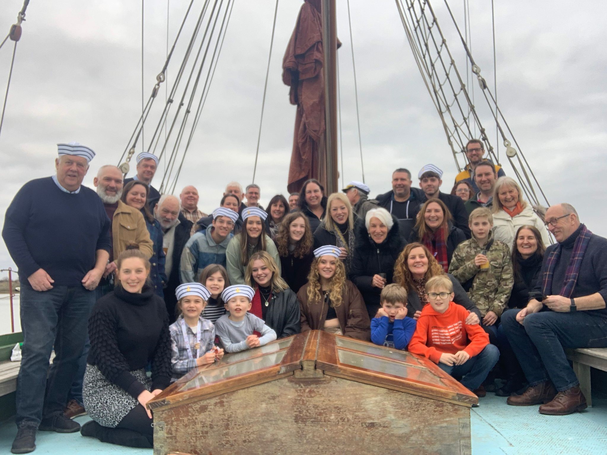 Group of guests enjoying a private event on deck of a vintage sailing barge